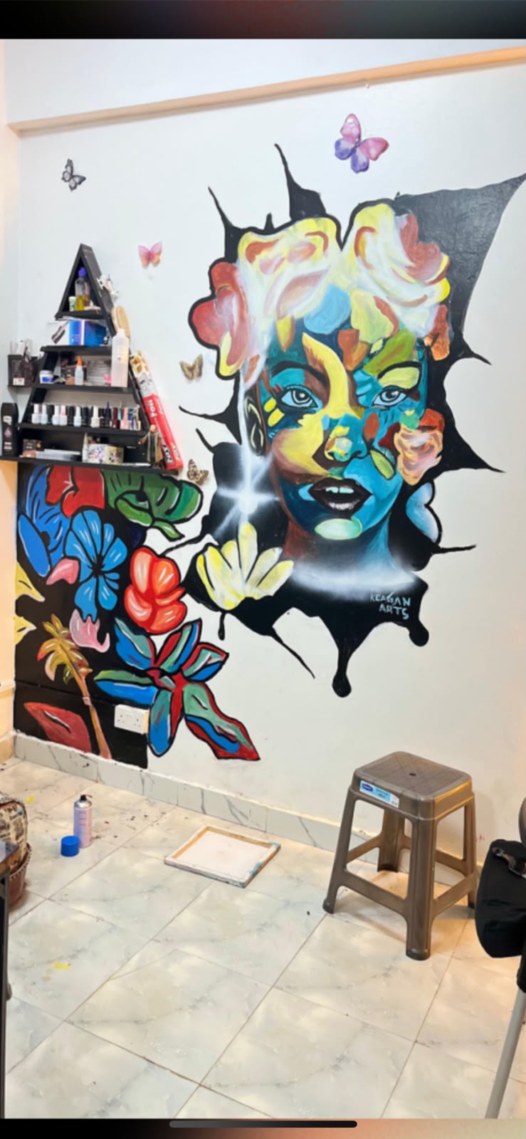 Studio mural of a woman's face erupting through a black splash of colour and flowers